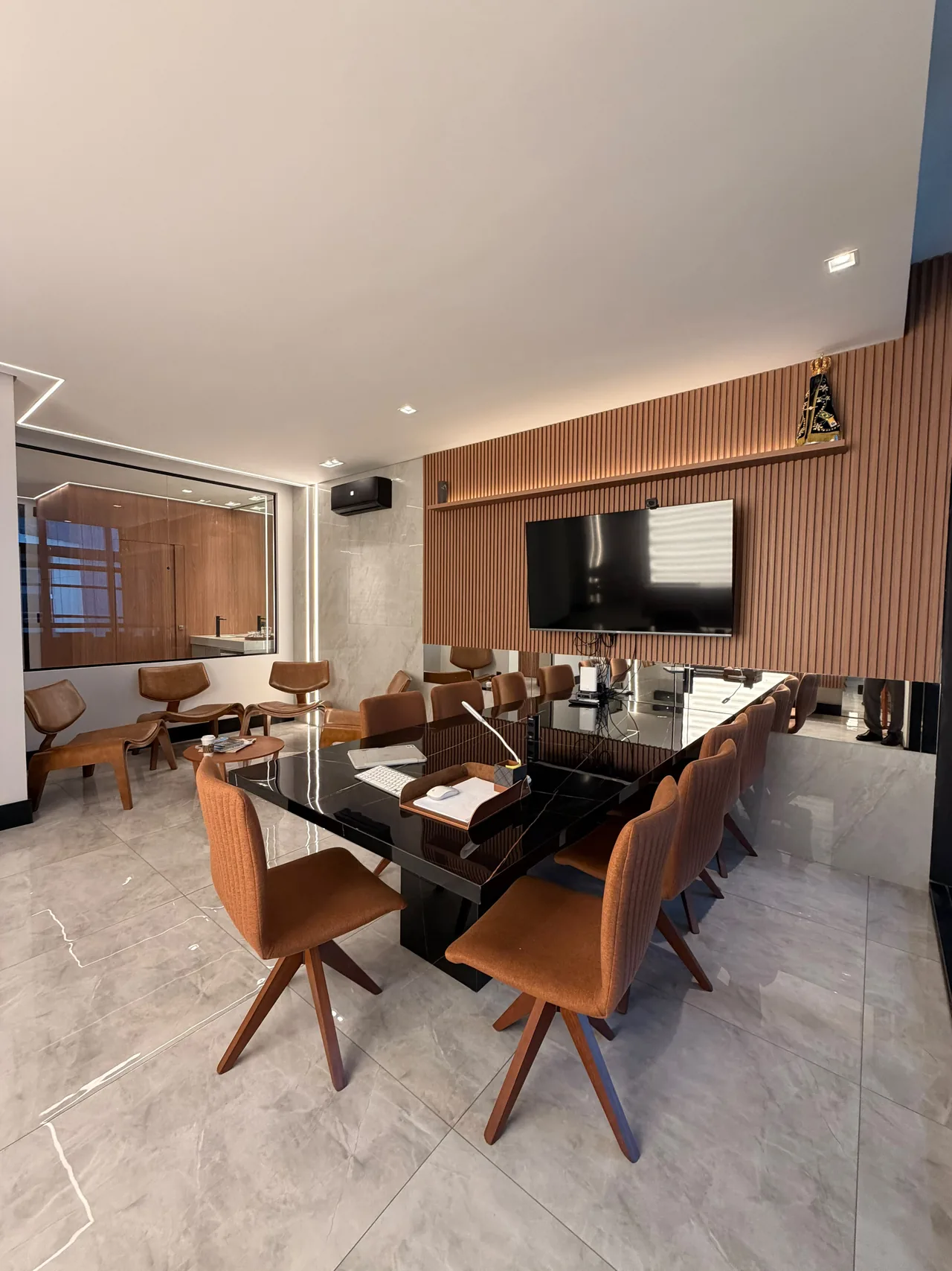 Sala de reuniões do escritório de Curitiba, com mesa, cadeiras e luz natural.